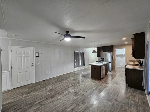 a kitchen with stainless steel appliances kitchen island wooden cabinets and granite counter tops
