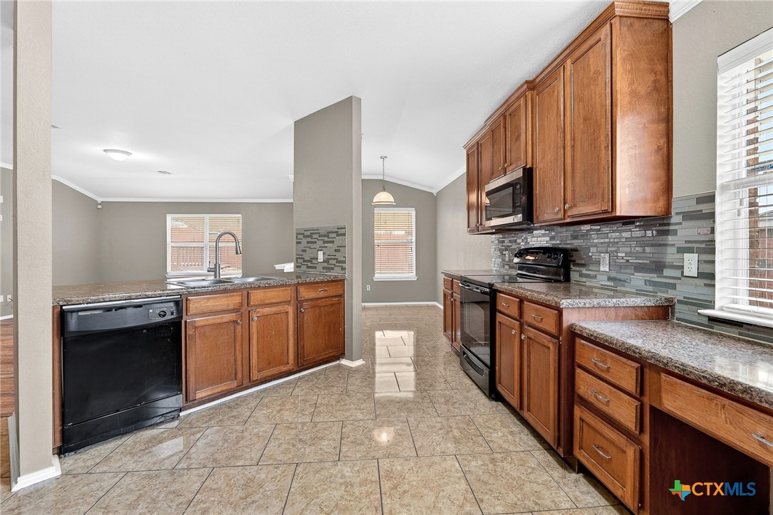 6300 Taree Loop Killeen, TX 76549 - Photo 3 of 13 a large kitchen with stainless steel appliances granite countertop a stove a sink and a microwave