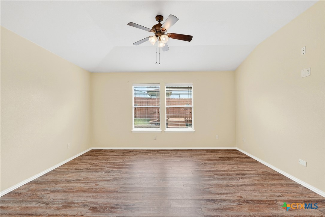 6300 Taree Loop Killeen, TX 76549 - Photo 5 of 13 an empty room with wooden floor chandelier fan and windows