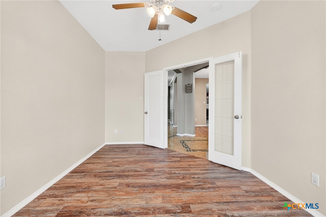 6300 Taree Loop Killeen, TX 76549 - Photo 8 of 13 a view of an empty room with wooden floor and a ceiling fan