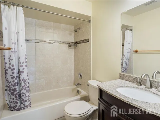 a bathroom with a granite countertop sink toilet a mirror and shower