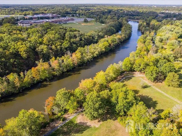 an aerial view of residential houses with outdoor space and lake view