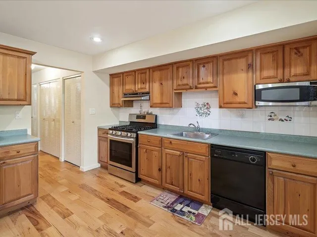 a kitchen with stainless steel appliances granite countertop a stove sink and cabinets