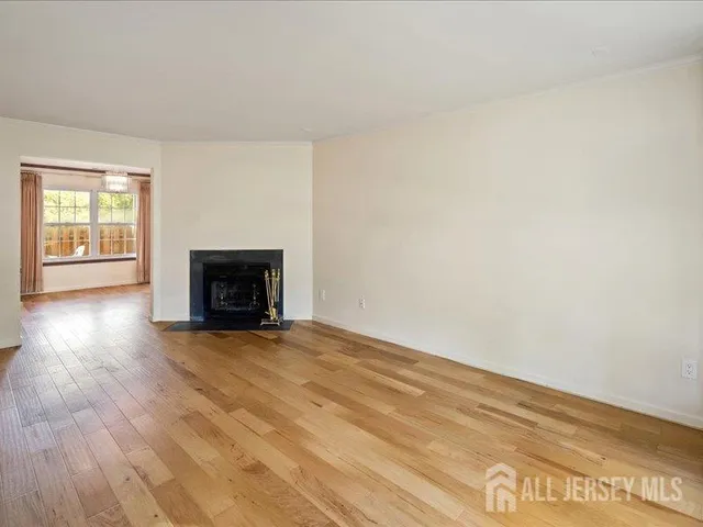 a view of empty room with wooden floor and fireplace