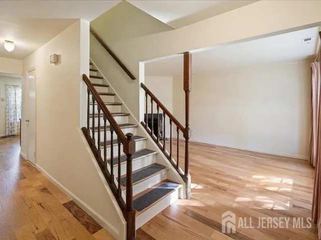 a view of staircase with wooden floor and white walls