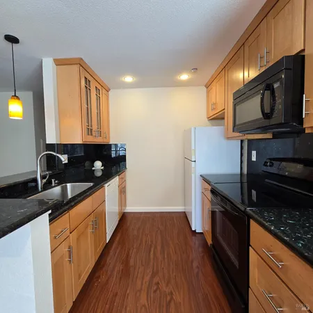a kitchen with stainless steel appliances granite countertop a stove a sink and a microwave