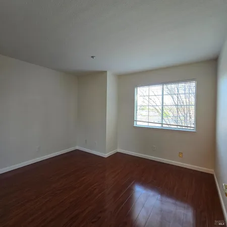 a view of a room with wooden floor and windows in it