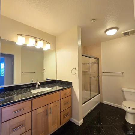 a spacious bathroom with a granite countertop sink mirror and toilet
