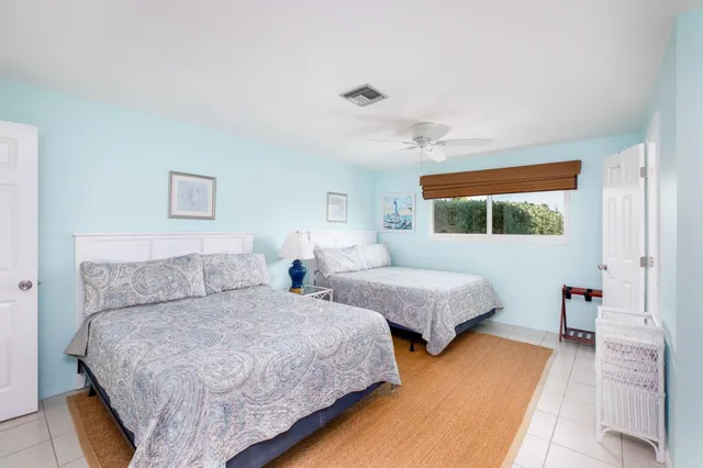 a bedroom with two beds and wooden floor