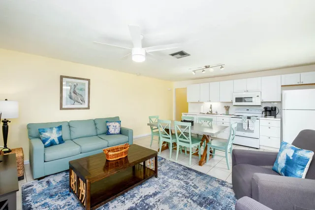 a living room with furniture kitchen view and a dining table