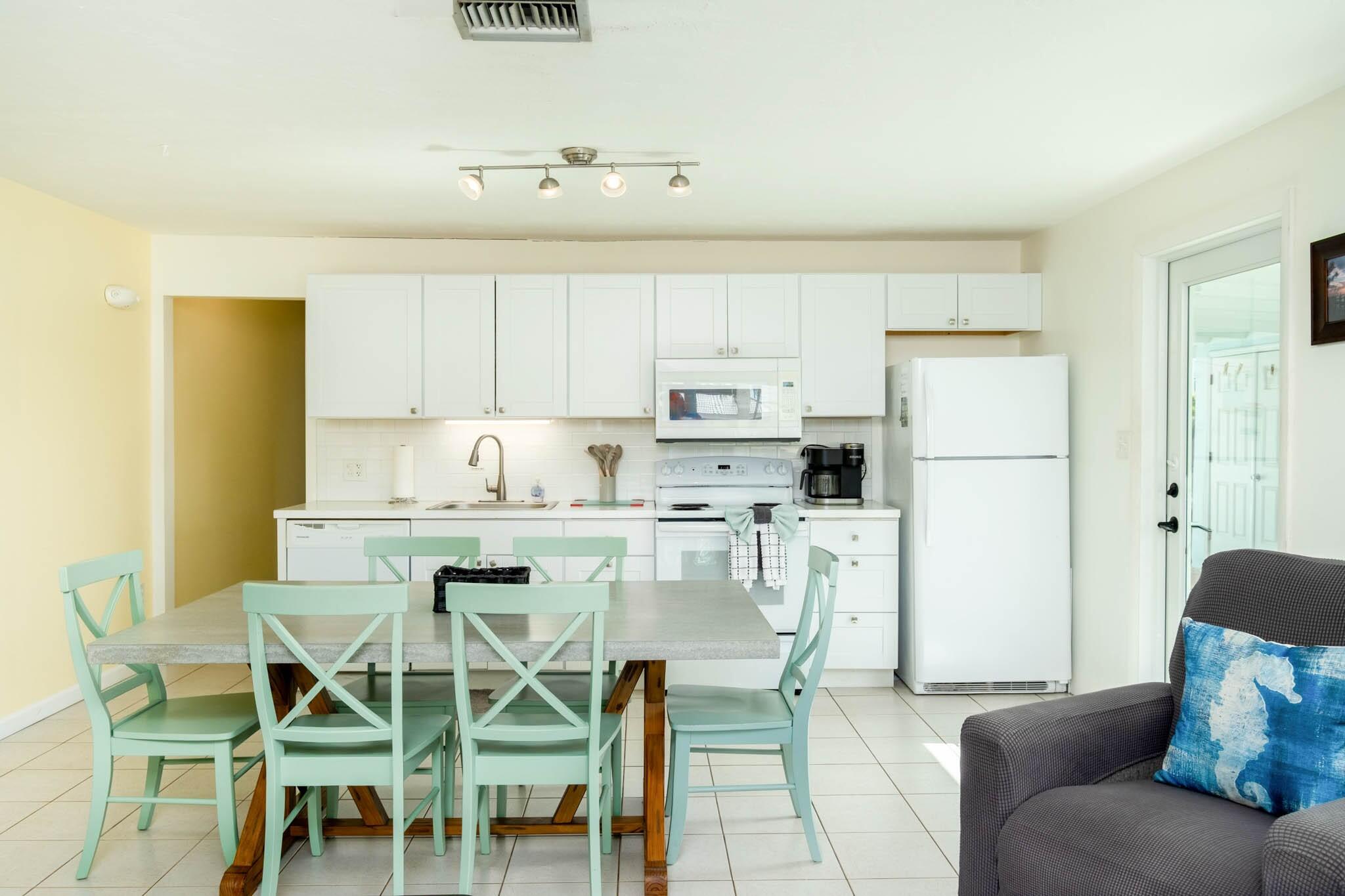 261 9th Street Key Colony Beach, FL 33051 - Photo 10 of 42 a kitchen with a dining table chairs and refrigerator