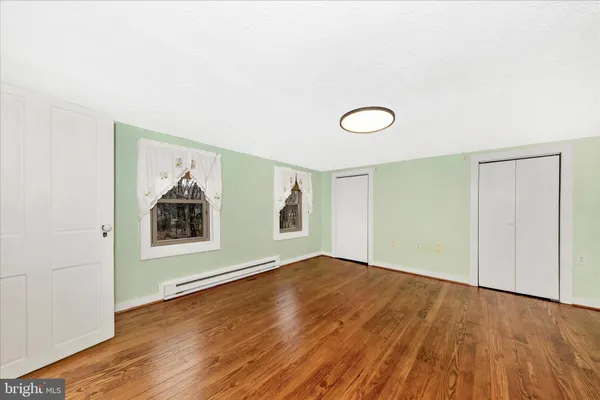 a view of a livingroom with wooden floor and a ceiling fan