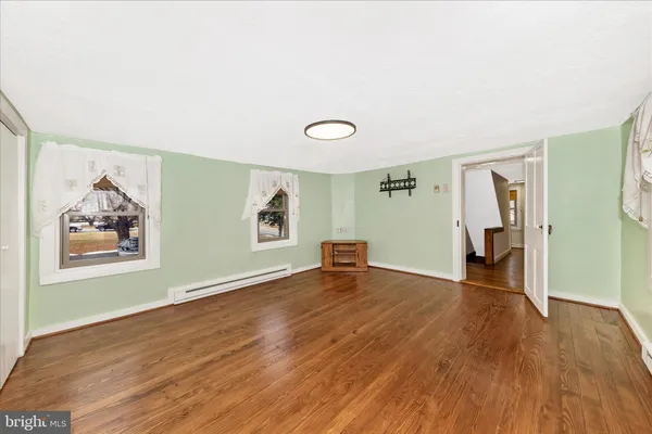 a view of a room with wooden floor and window