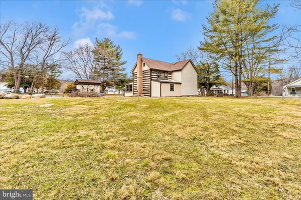 a front view of a house with a yard and potted plants