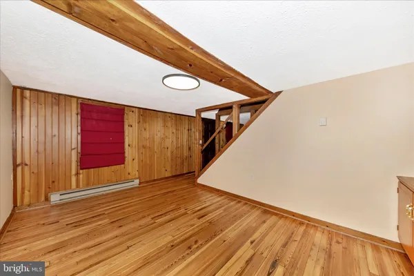 a view of an empty room with wooden floor
