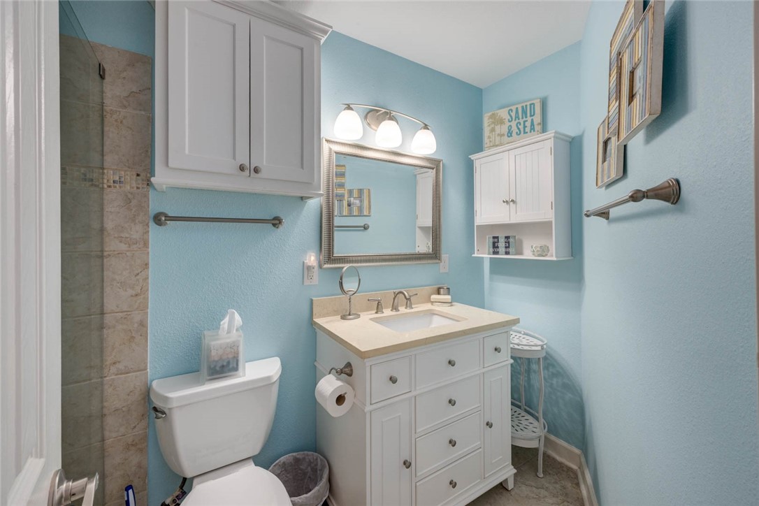 2290 North Fulton Beach Road, Unit 315 Rockport, TX 78382 - Photo 11 of 25 a bathroom with a toilet sink and mirror