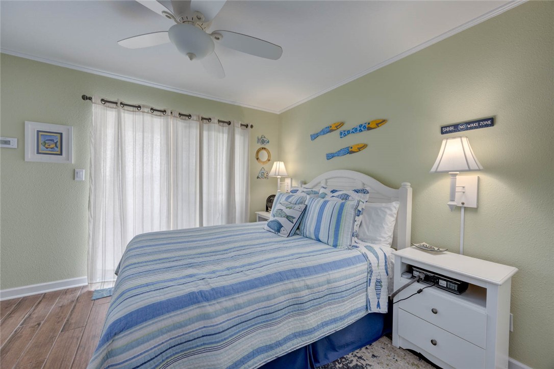 2290 North Fulton Beach Road, Unit 315 Rockport, TX 78382 - Photo 14 of 25 a bedroom with a bed and a chandelier