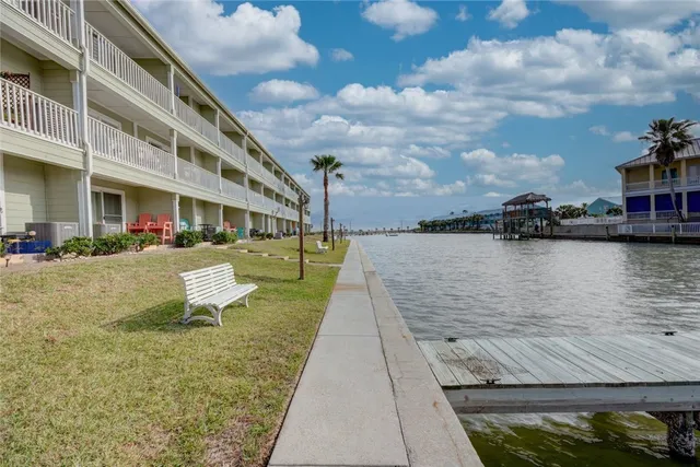 a view of a lake with a building and trees in the background