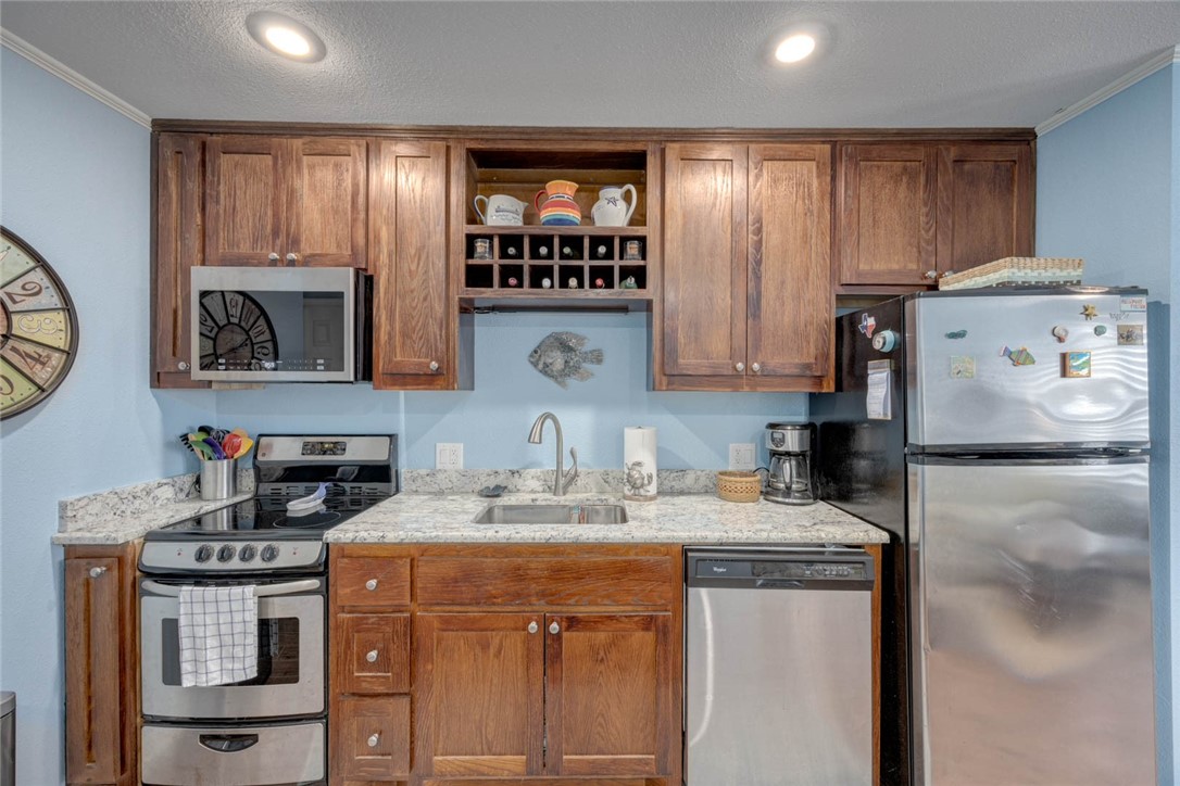 2290 North Fulton Beach Road, Unit 315 Rockport, TX 78382 - Photo 8 of 25 a kitchen with stainless steel appliances granite countertop a sink stove and refrigerator
