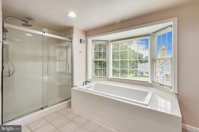 a spacious bathroom with a large tub shower and sink