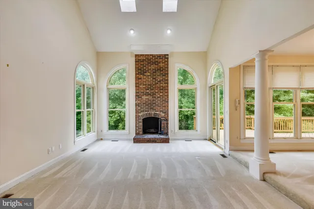 a view of an empty room with a fireplace and a window
