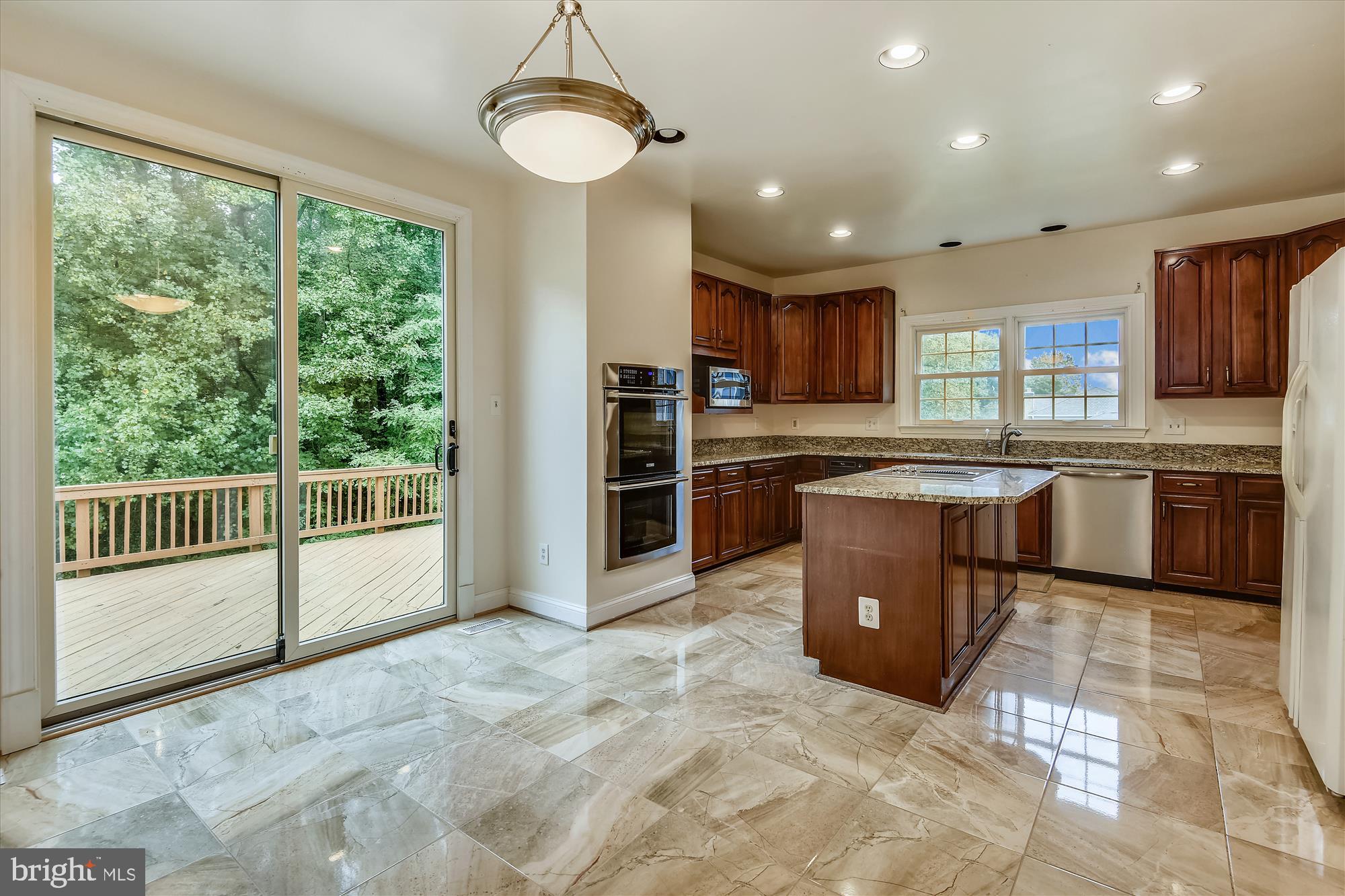 9715 Middleton Ridge Road Vienna, VA 22182 - Photo 8 of 29 a large kitchen with stainless steel appliances granite countertop a stove top oven a sink dishwasher a dining table and chairs with wooden floor