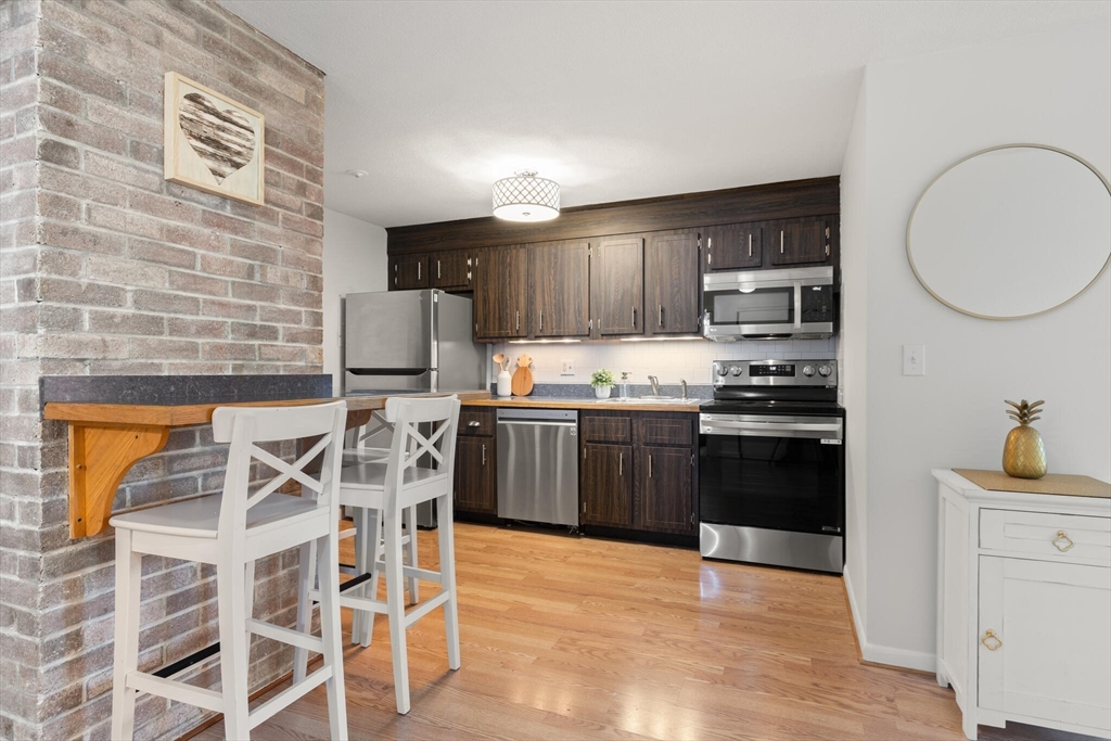 96 Richardson Road, Unit B23 North Chelmsford, MA 01863 - Photo 14 of 31 a kitchen with stainless steel appliances kitchen island granite countertop a stove a sink and a refrigerator