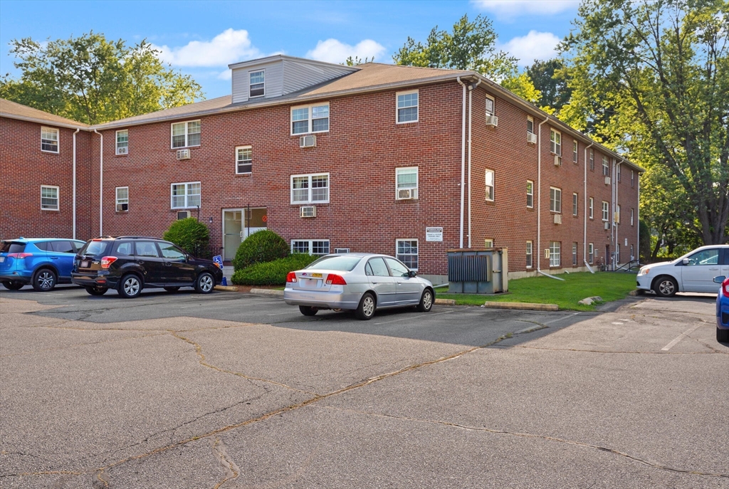 96 Richardson Road, Unit B23 North Chelmsford, MA 01863 - Photo 26 of 31 a car parked in front of a brick building