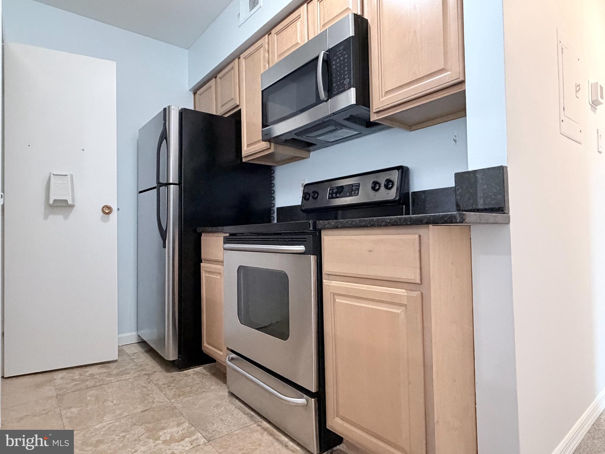 5823 S Royal Ridge Drive Springfield, VA 22152 - Photo 6 of 30 a utility room with stainless steel appliances white cabinets and a refrigerator