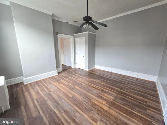 a view of empty room with wooden floor