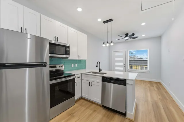 a kitchen with stainless steel appliances a refrigerator sink and stove