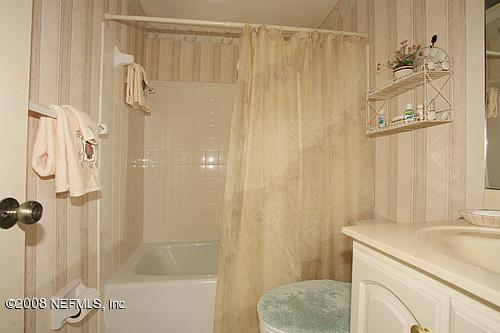 6803 Clifton Forge Road Jacksonville, FL 32277 - Photo 3 of 8 a bathroom with a shower curtain and a sink