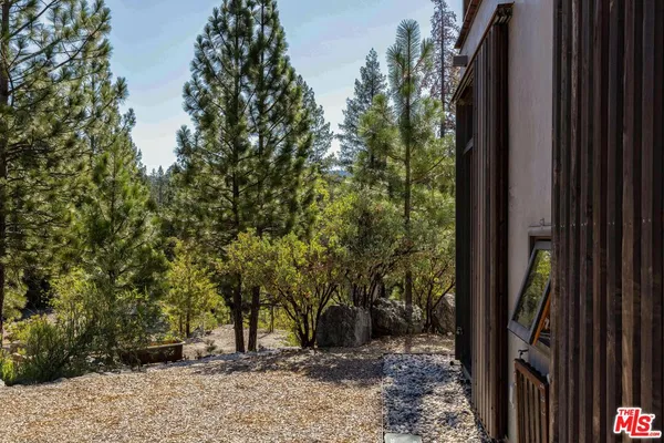 a front view of a house with trees and plants