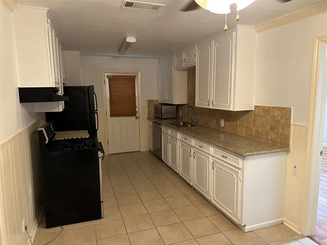 a kitchen with granite countertop a refrigerator and a stove