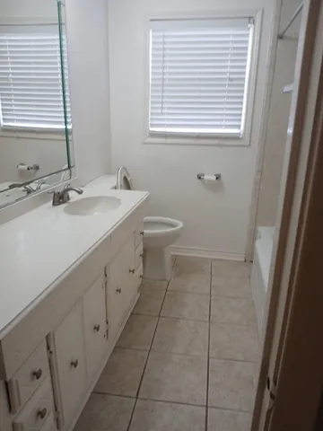 a bathroom with a sink a toilet and a window