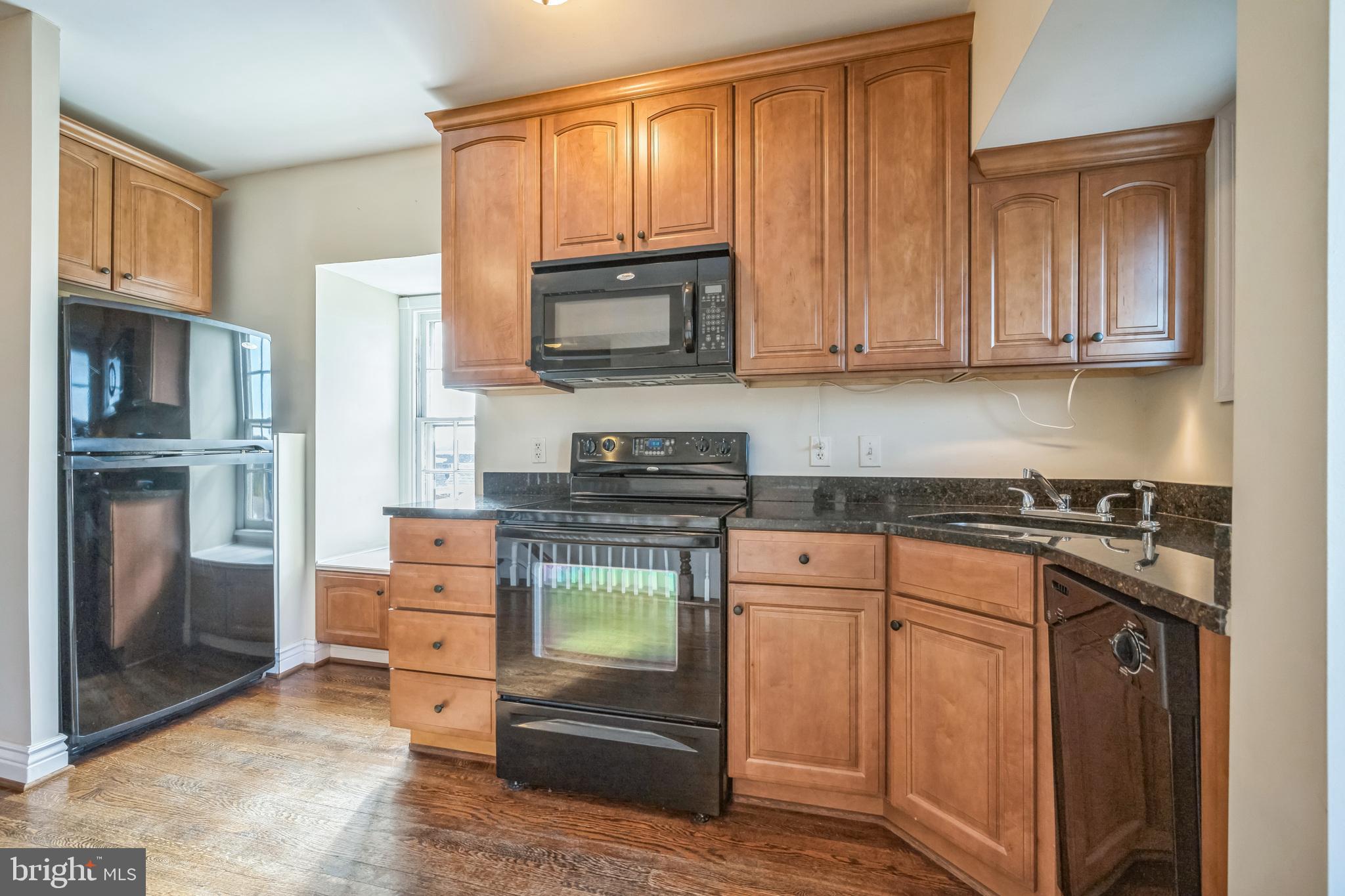 37 South Prospect Street, Unit 401 Hagerstown, MD 21740 - Photo 9 of 15 a kitchen with stainless steel appliances granite countertop a stove top oven a refrigerator and a granite counter tops