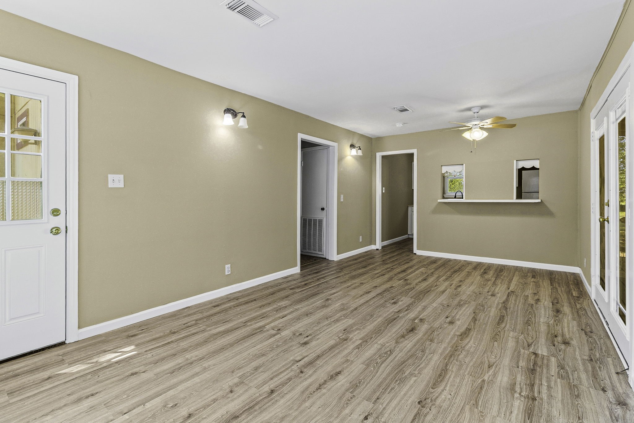 81 Westlake Road Trinity, TX 75862 - Photo 16 of 25 Bright and inviting living area featuring elegant wood-style flooring, neutral walls, and ample natural light through French doors.