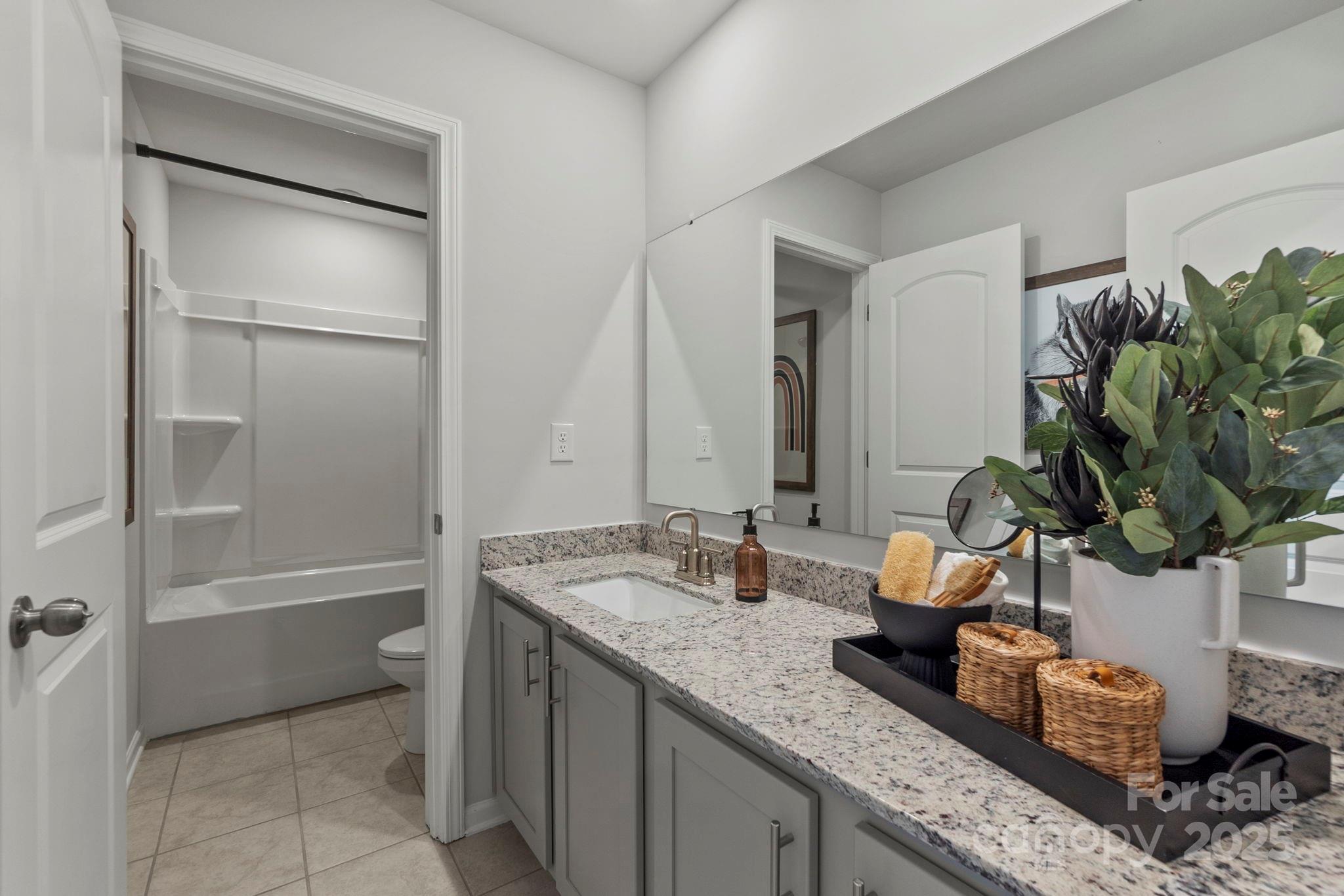 8130 Chilkoot Lane Locust, NC 28097 - Photo 17 of 28 a bathroom with a granite countertop sink and a mirror