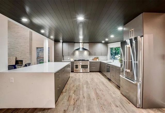 a large kitchen with stainless steel appliances granite countertop a stove and a sink