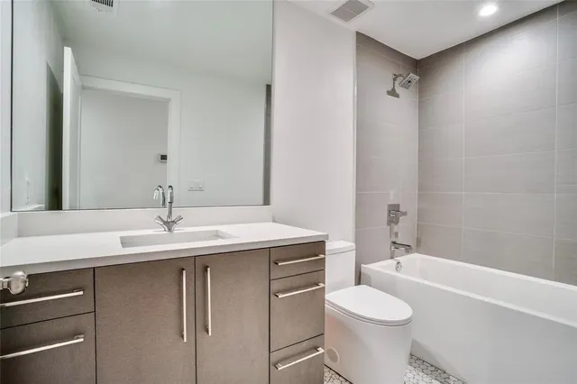 a bathroom with a granite countertop sink toilet mirror and shower