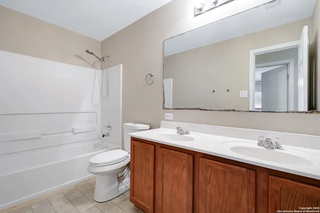 a bathroom with a sink toilet vanity and shower