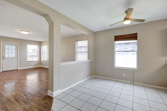 a view of an empty room with window and wooden floor
