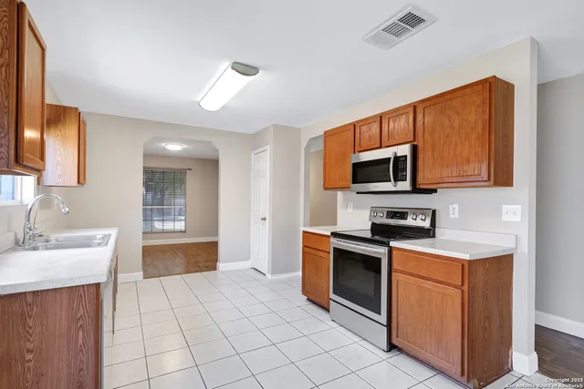a kitchen with stainless steel appliances a stove sink microwave and cabinets