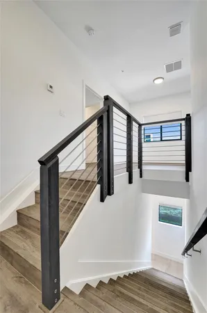 a view of staircase with white walls and railing