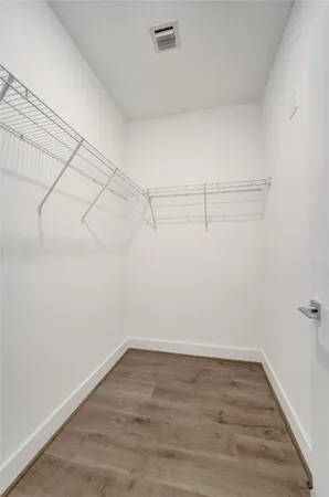 a view of a room with wooden floor and cabinets