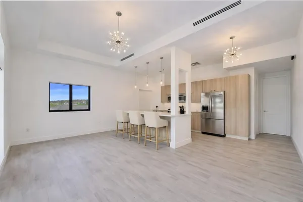 a view of a kitchen with furniture and a refrigerator