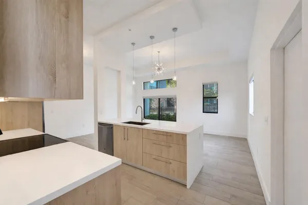 a kitchen with kitchen island a sink counter top space and cabinets