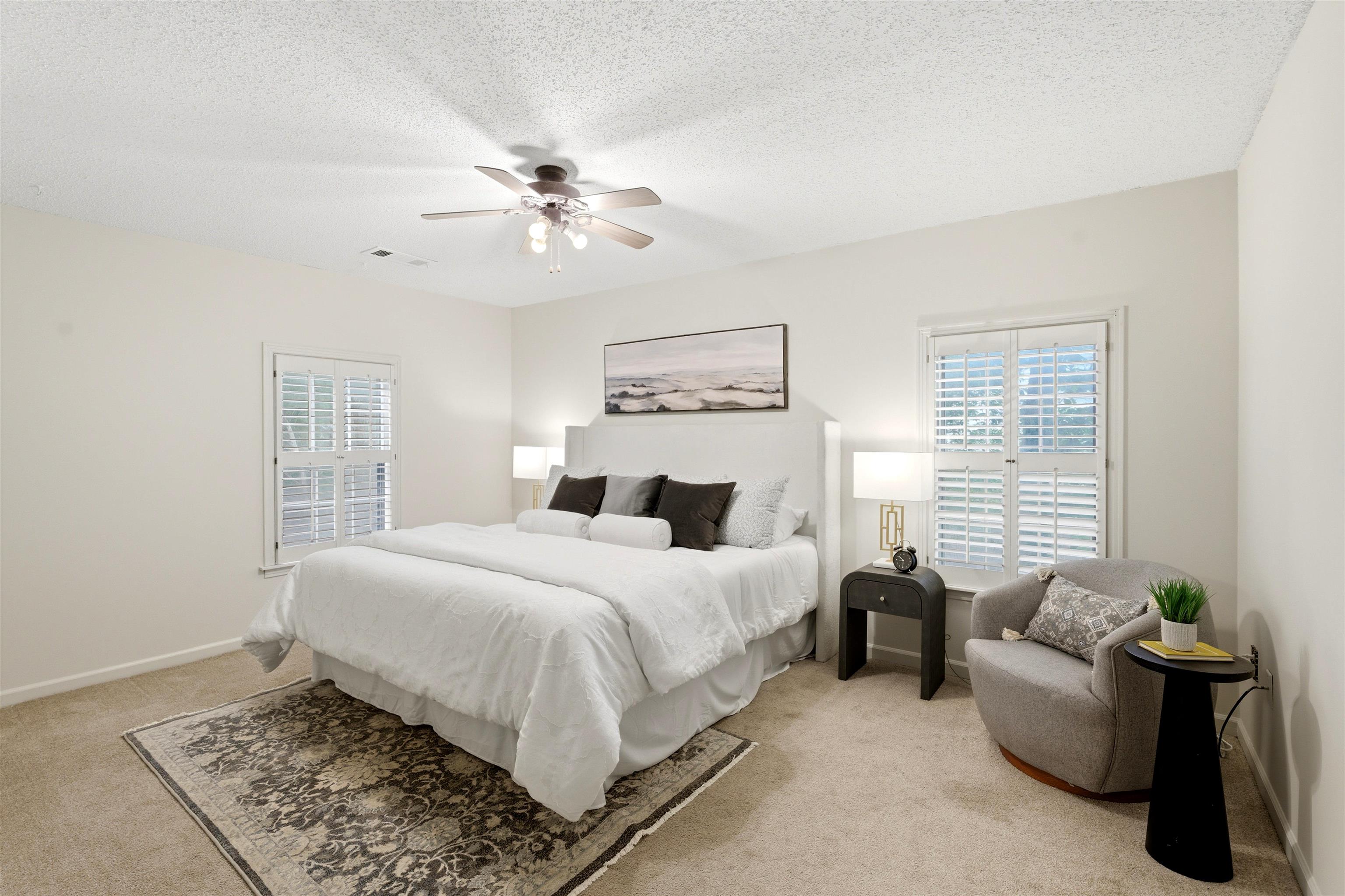 1984 Allenby Road Germantown, TN 38139 - Photo 26 of 37 Carpeted room featuring two windows with white plantation shutters, a ceiling fan with integrated lighting, and neutral wall paint