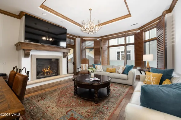 a living room with furniture a fireplace and a chandelier