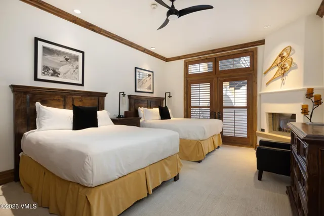 a spacious bedroom with two beds and a chandelier